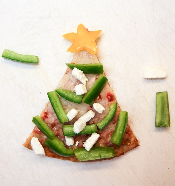 How to throw a holiday decorate-your-own pizza party. It's super-easy with some different types of cheeses, ready-made pizza dough, cookie cutters and toppings.