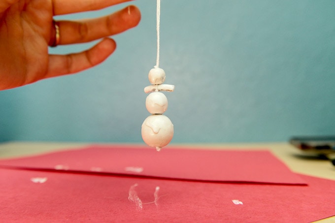 Melting snowman ornament craft made with macaroni, beads and paint