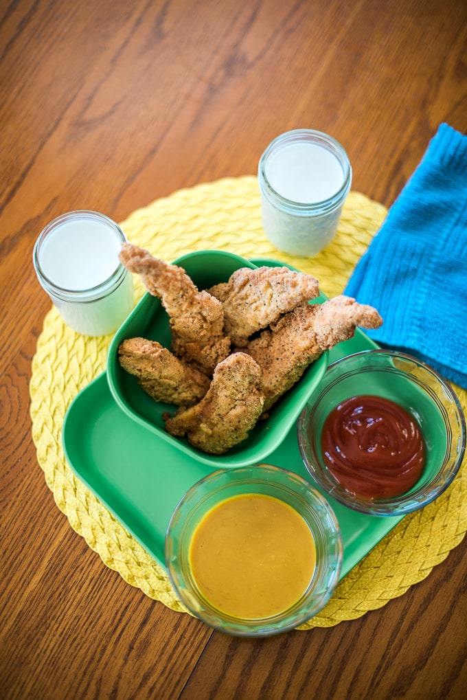 Quick and easy gluten-free chicken fingers (made with almond flour with an easy one-to-one substitute option for cassava flour). These have a really slight tang that keeps adults interested and keeps kids drinking up their milk!