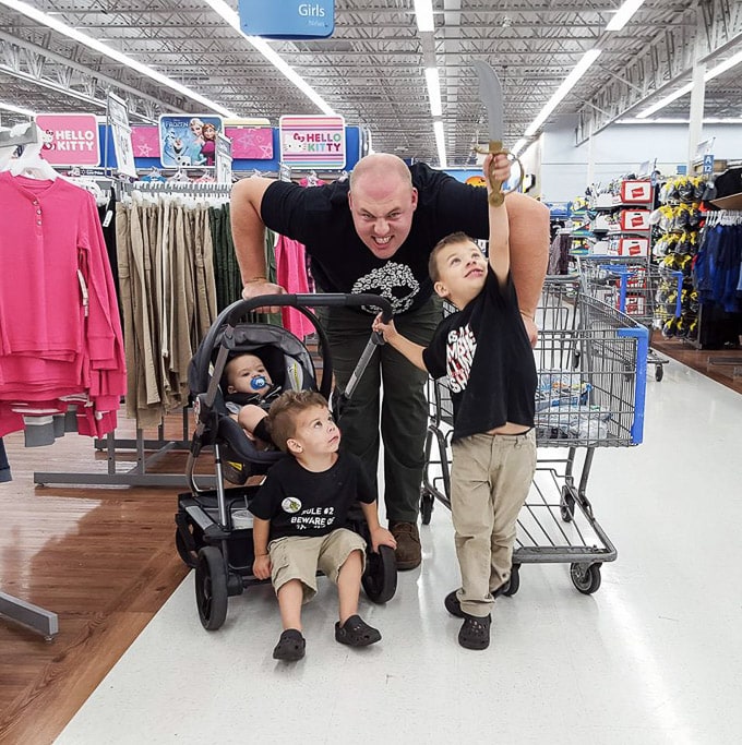 Dad and three costumed zombie boys making a late-night Halloween stop at the store.
