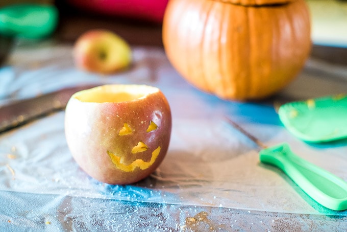 Making jack-o-lantern fruit bowls with apples
