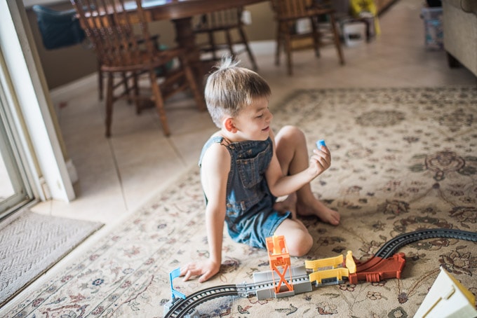 Boy playing with Thomas the Train track barrel