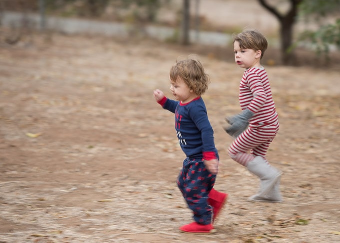 Little boys running through the yard in their pajamas.
