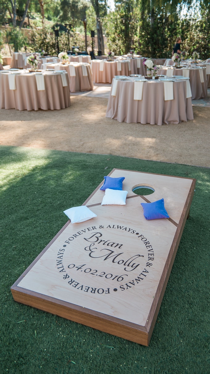 Setup a bean bag toss to keep guests occupied during happy hour at an outdoor wedding (games and activities like this can help buy the couple some more time for photos!)