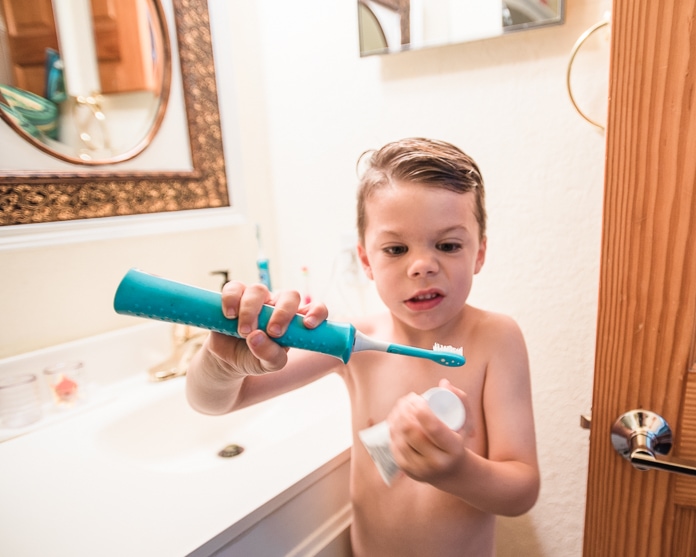 4-year-old spreading toothpaste on toothbrush