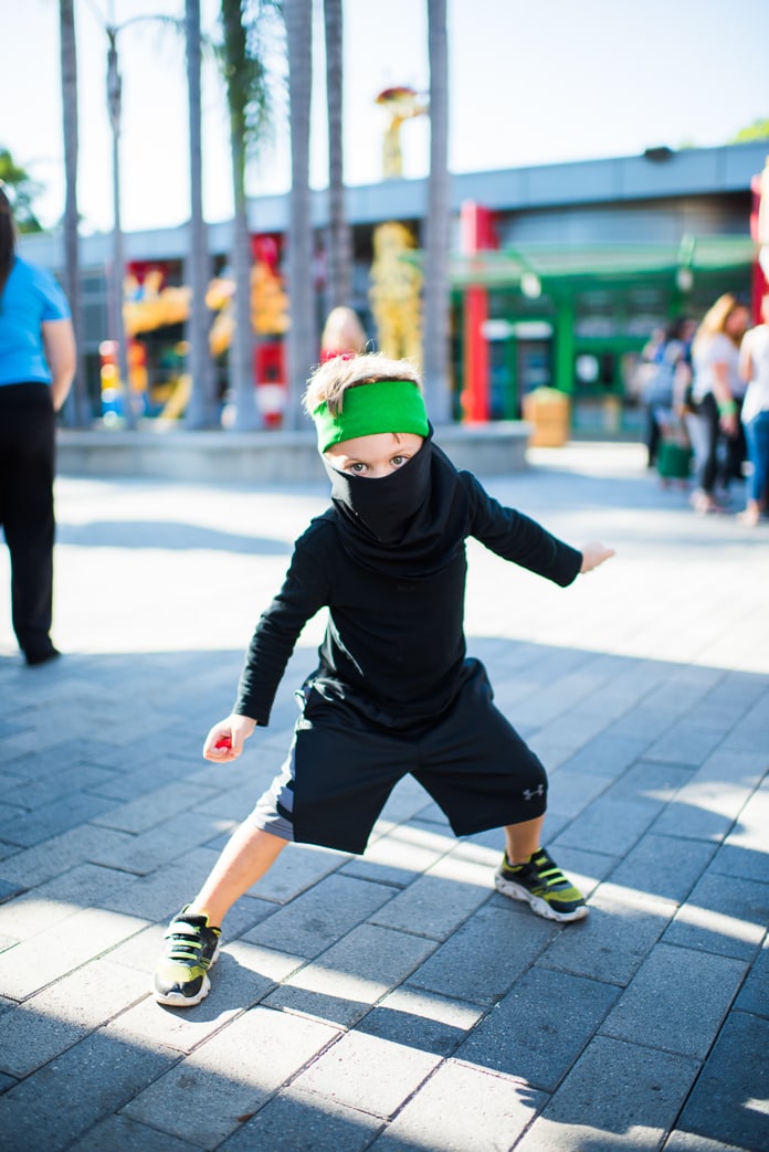Dressed like Lloyd from The LEGO NINJAGO movie with an all-black outfit and simple green sweatband