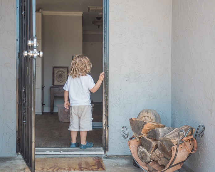 Toddler looking into a house with a security system