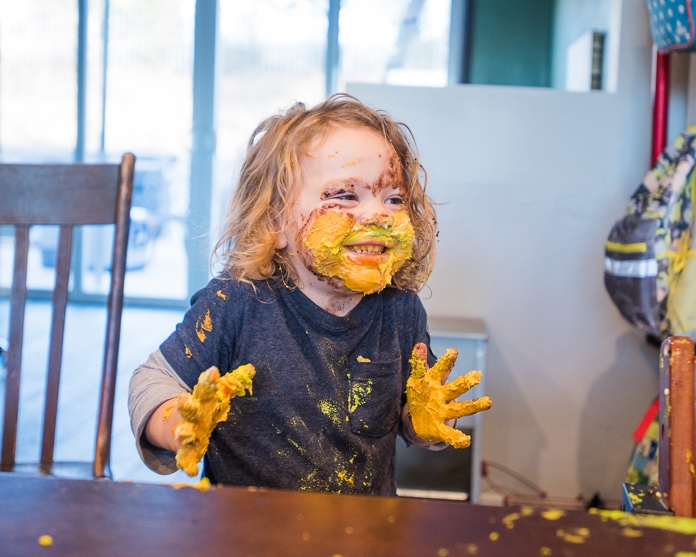 2 year old taking part in the first birthday cake smash