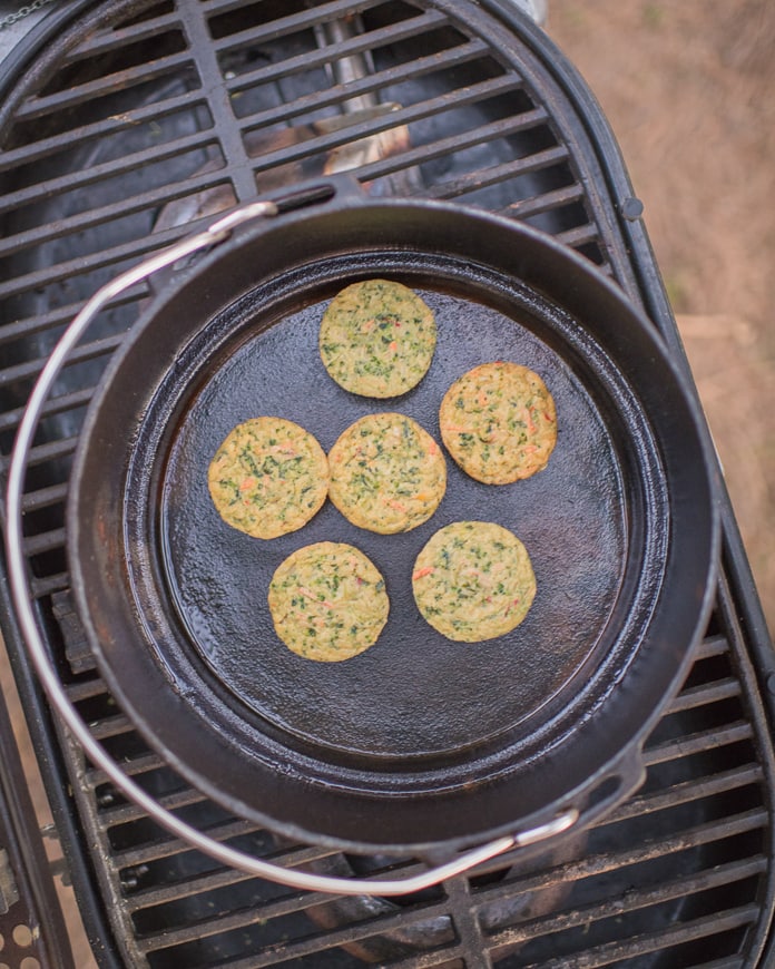 Vegetable muffins cooking in a cast iron skillet at camp