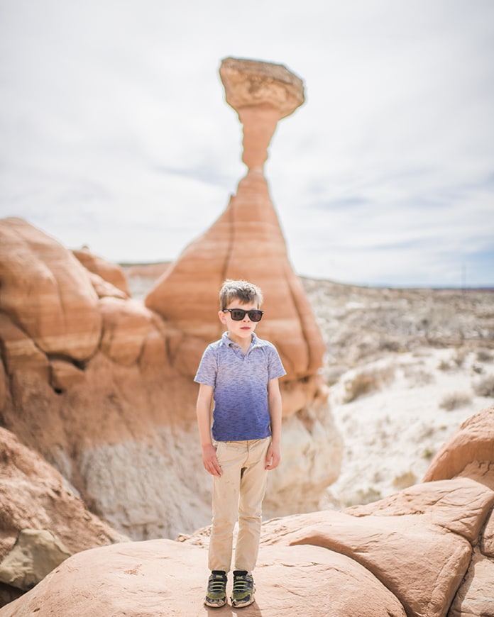 Boy standing in front of rock formation