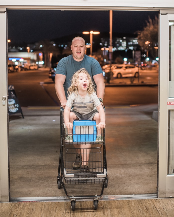 Wheeling a preschooler into grocery store in a cart