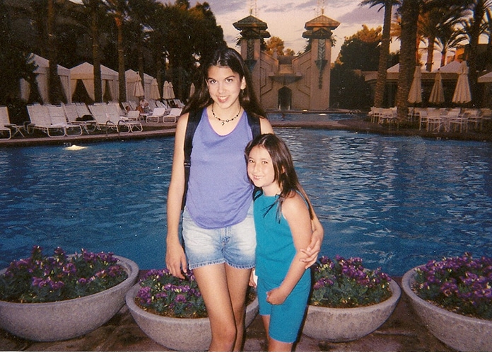 Sisters standing by a pool