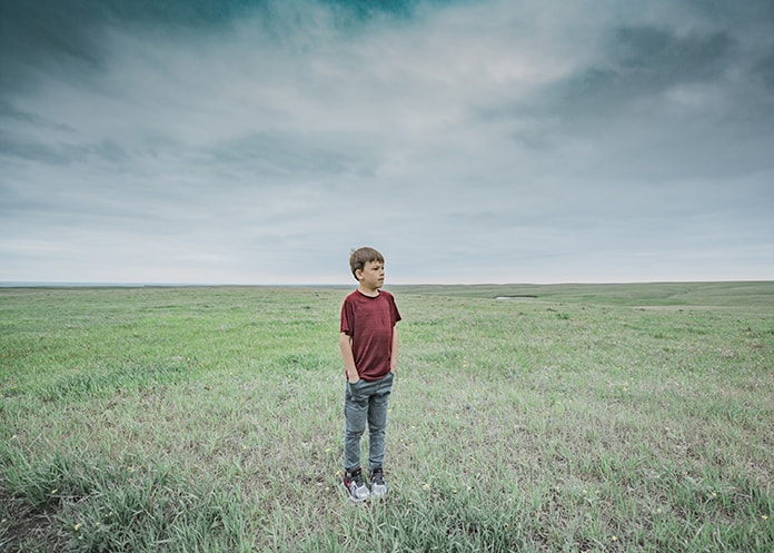 Boy standing in the middle of the great plains