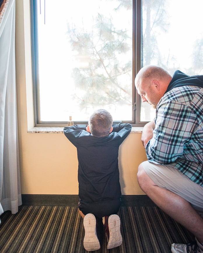 Father and son sitting at window together