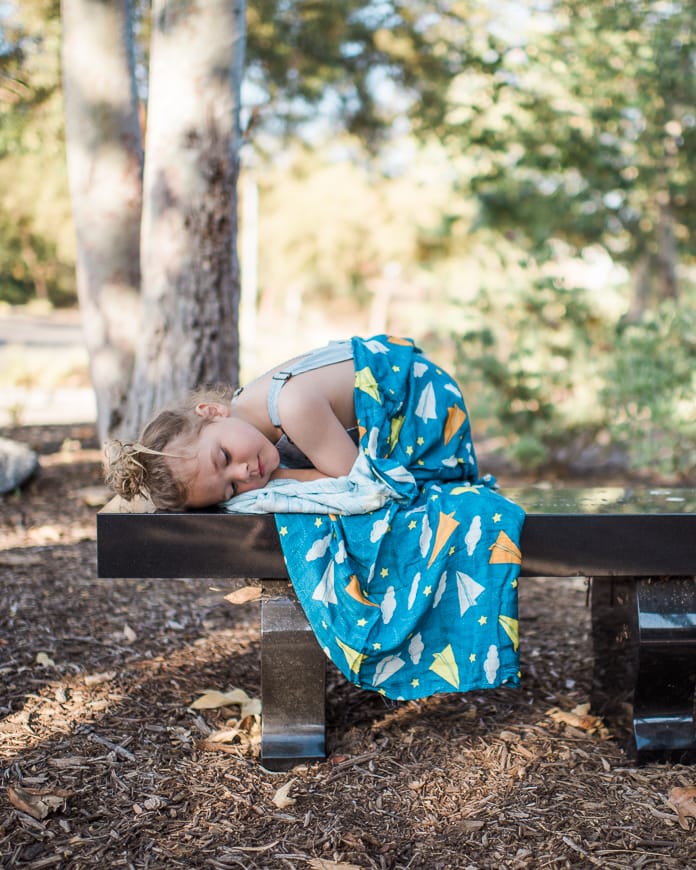 Kid napping on a bench