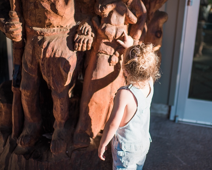 Preschooler looking at a wood statue