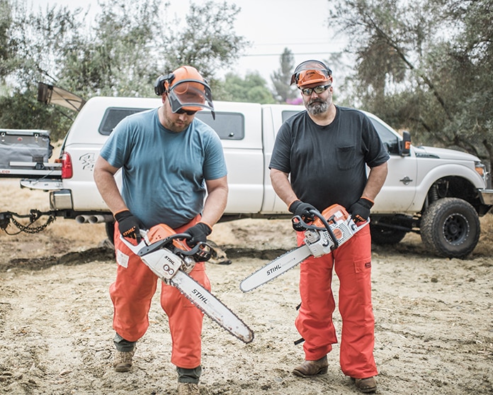 Two men with chainsaws