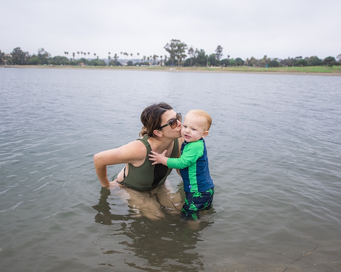 mother kissing her baby in the water