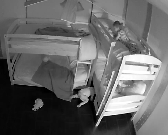Baby crawling under bed on baby monitor