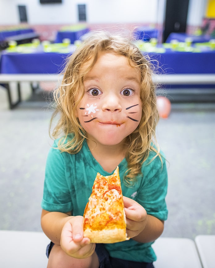 small child eats pizza