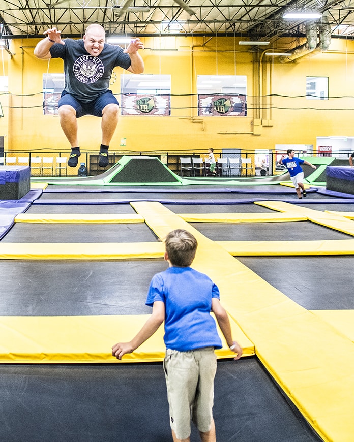 father and son jumping on trampoline