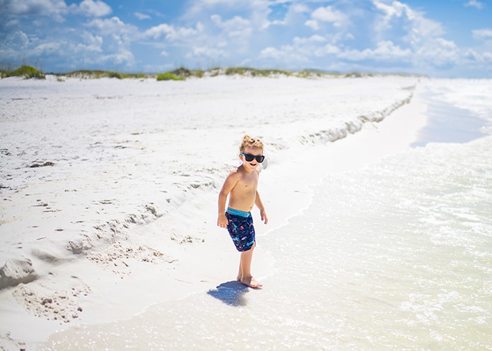 child playing on white sandy beach