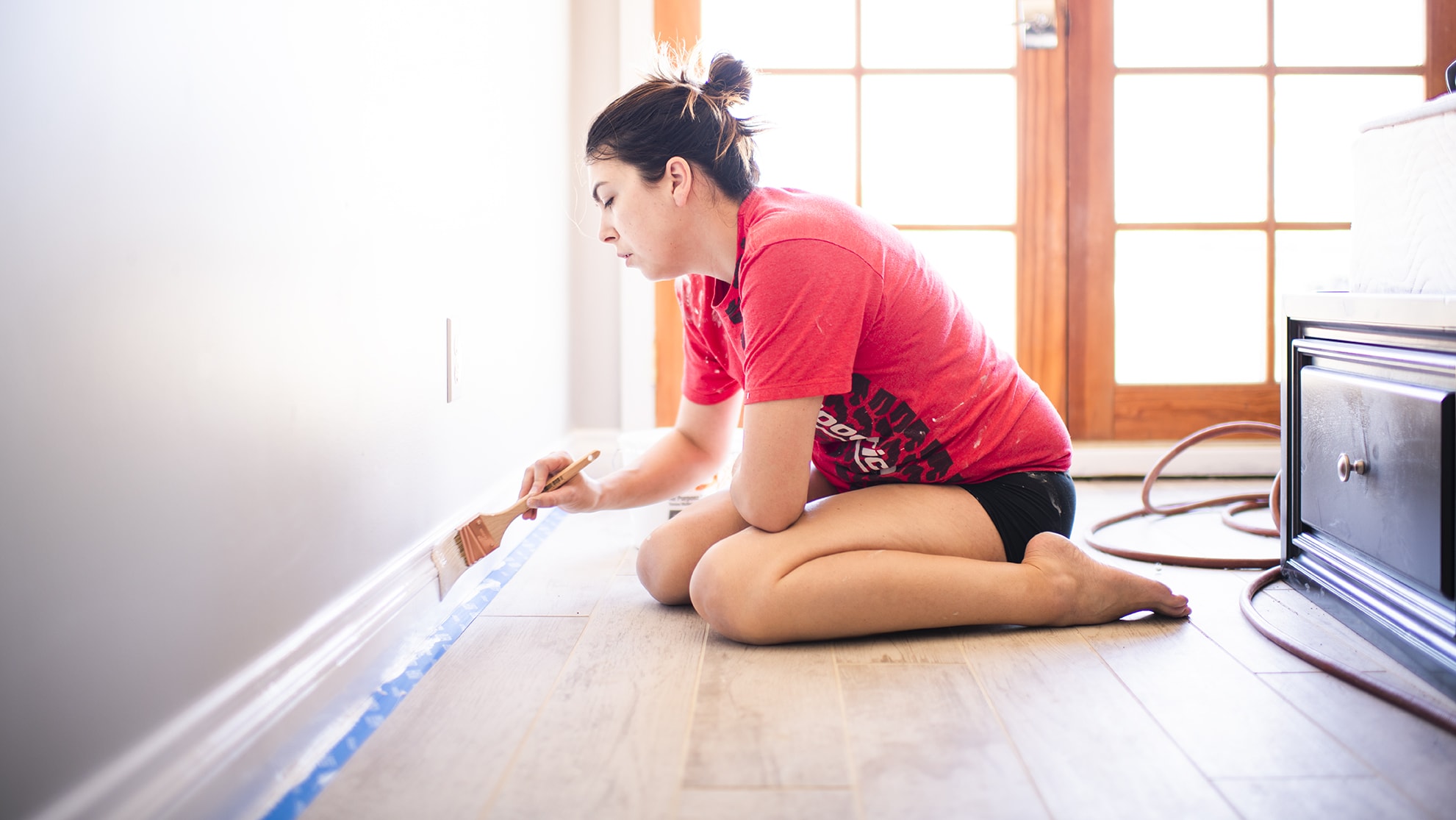 Woman painting base boards