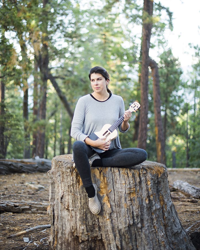 woman playing ukulele in forest