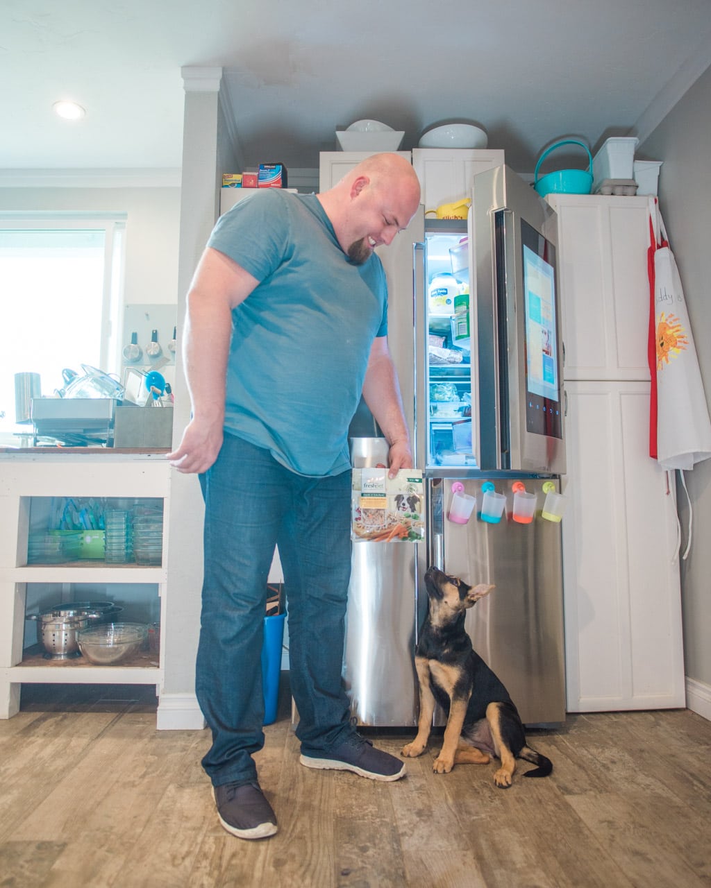 dog owner holding dog food by refrigerator