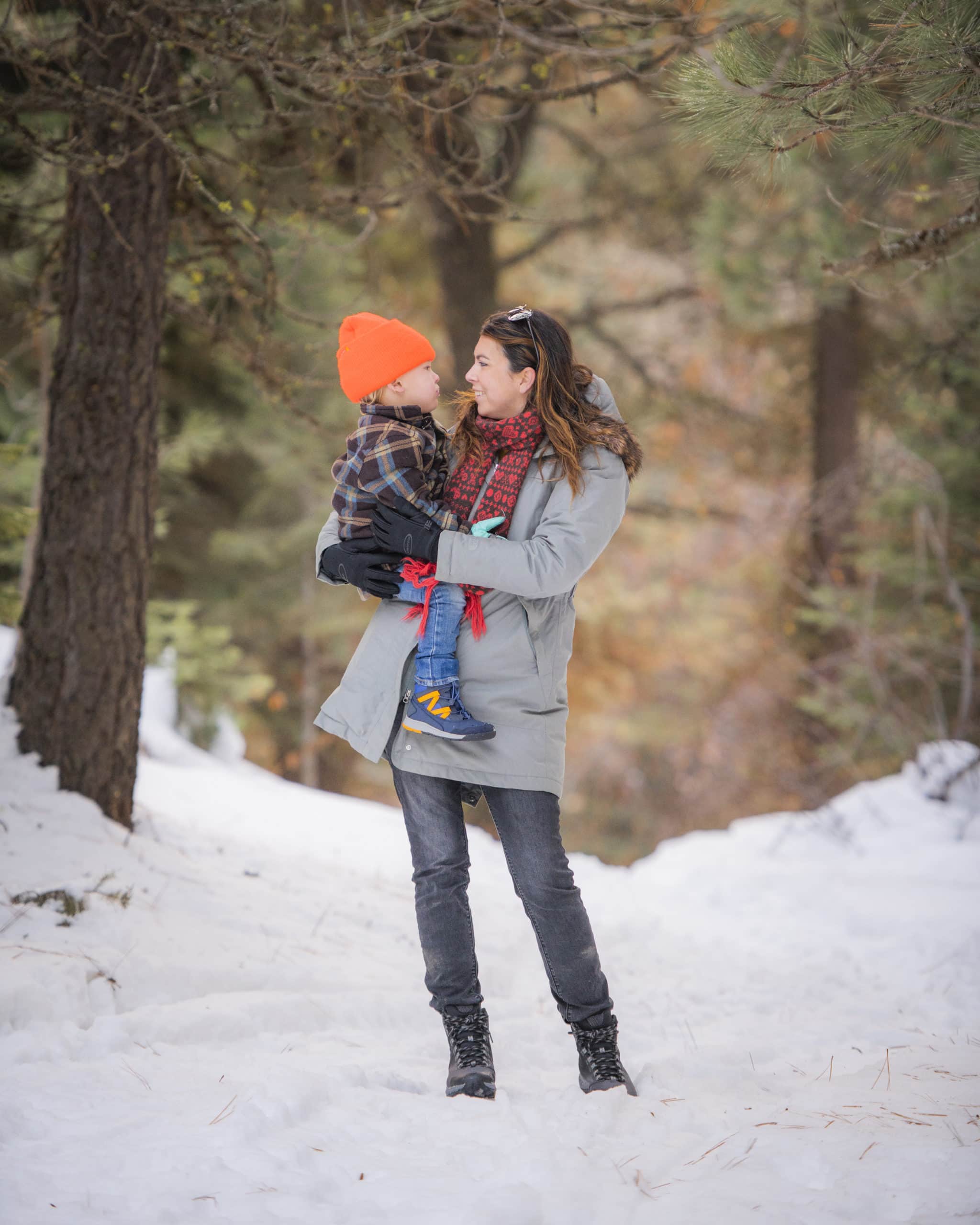 Mother holding baby in snow with merrell snow boots