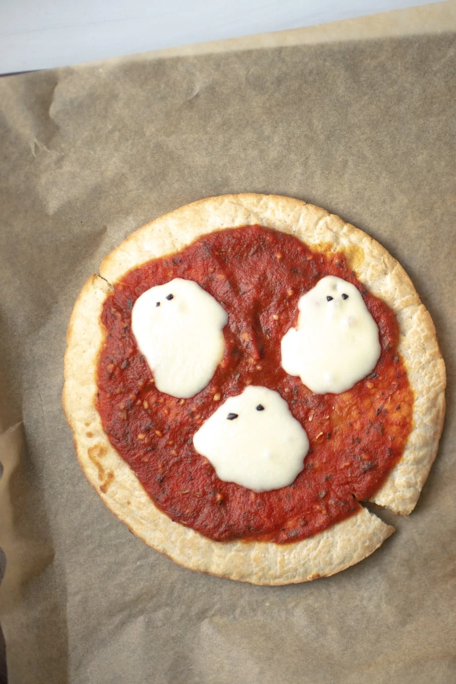 Cute ghost pizza made with white cheese and pizza crusts