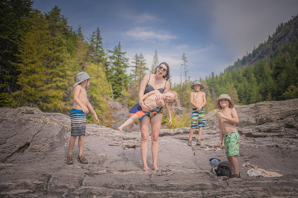 Family playing at red rock point in glacier national park