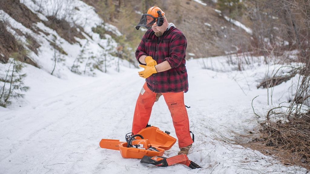 Putting on gloves to use stihl chainsaw truck gear while overlanding