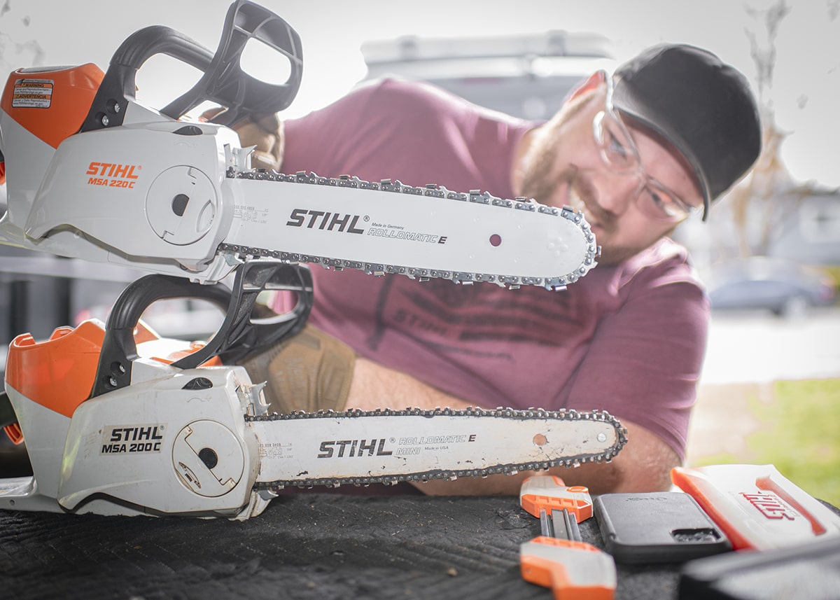 Nate day examining the difference between two different stihl battery powered chainsaws