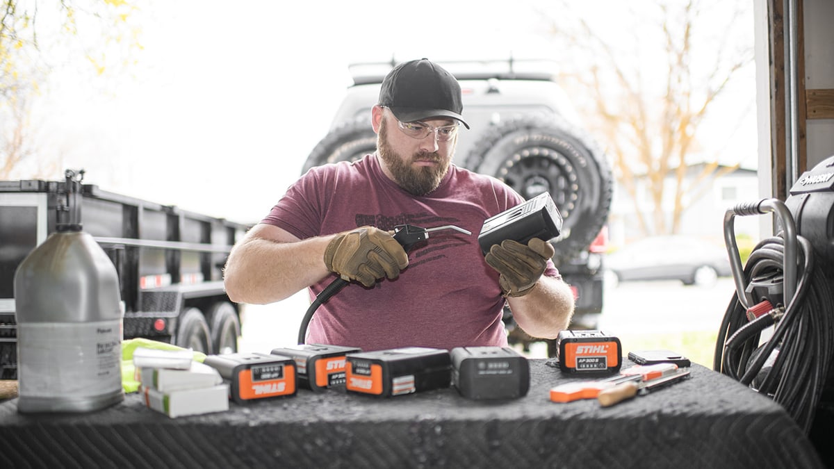 Nate day using an aircompressor to clean his stihl battery powered chainsaws batteries