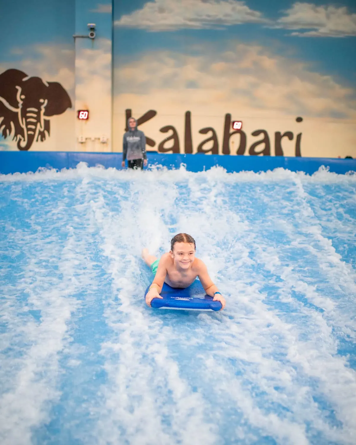 Waterpark resort 3 boy riding surf wave at indoor waterpark